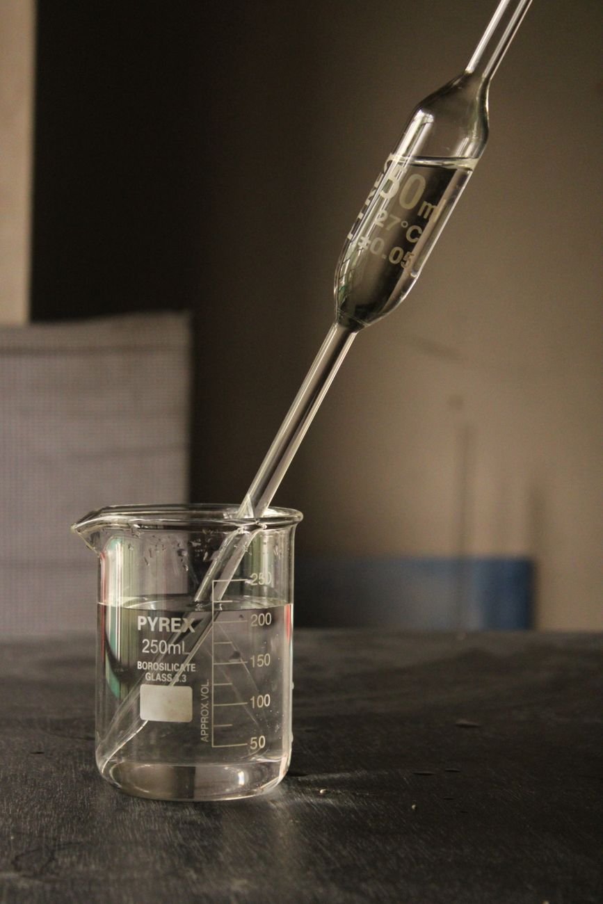 Laboratory beaker with a pipette containing liquid.
